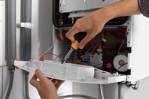 Image of a workman with screwdriver fixing the front panel on the door of a boiler