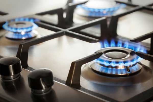Image of a gas hob with blue flames burning
